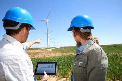Engineers using tablet on wind turbine site